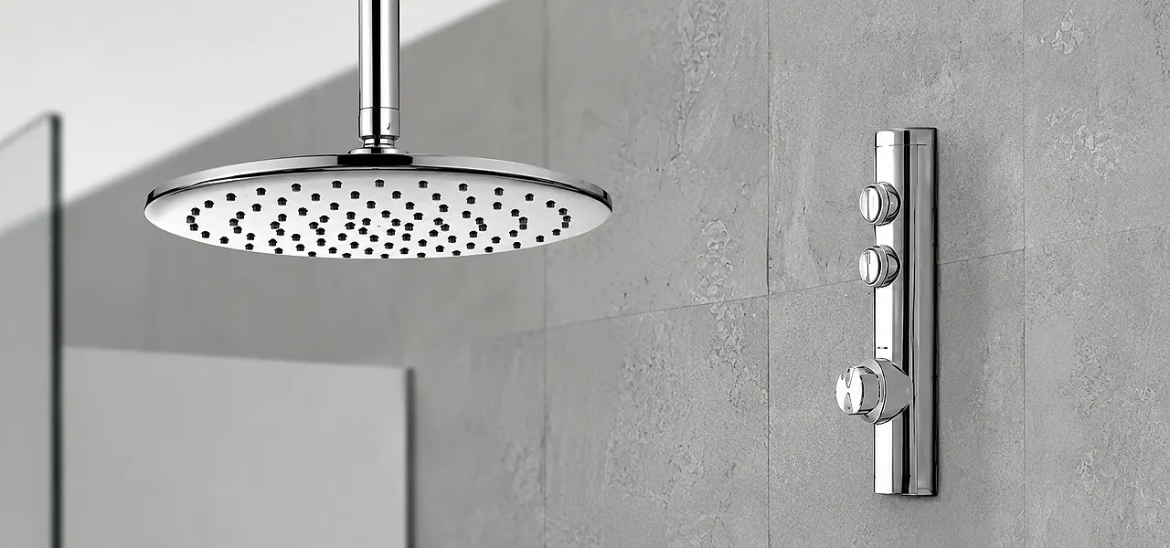 Aqualisa digital controller showing 38 degrees on a dark-tiled wall, filling a bath through a chrome overflow filler.