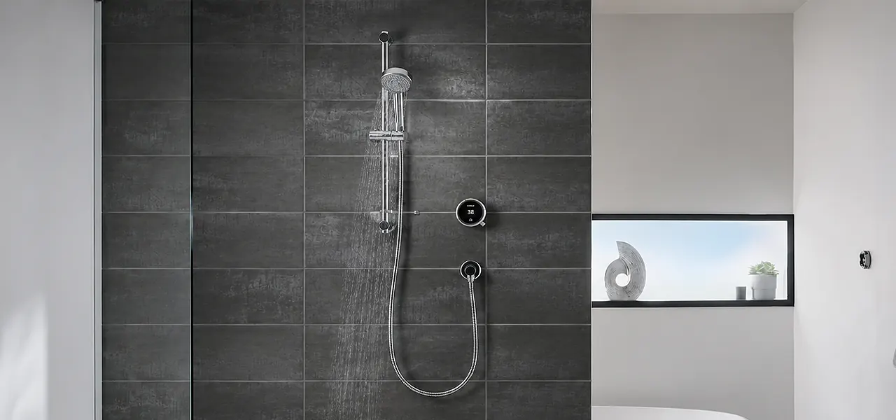 Aqualisa digital shower with an adjustable handset on a chrome riser rail, a round black digital controller, and a chrome wall outlet.