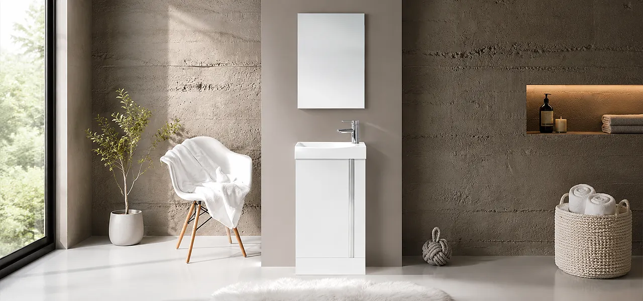 Small white floor-standing cloakroom vanity unit with a slimline basin, chrome tap and rectangular mirror, against a concrete-effect wall.