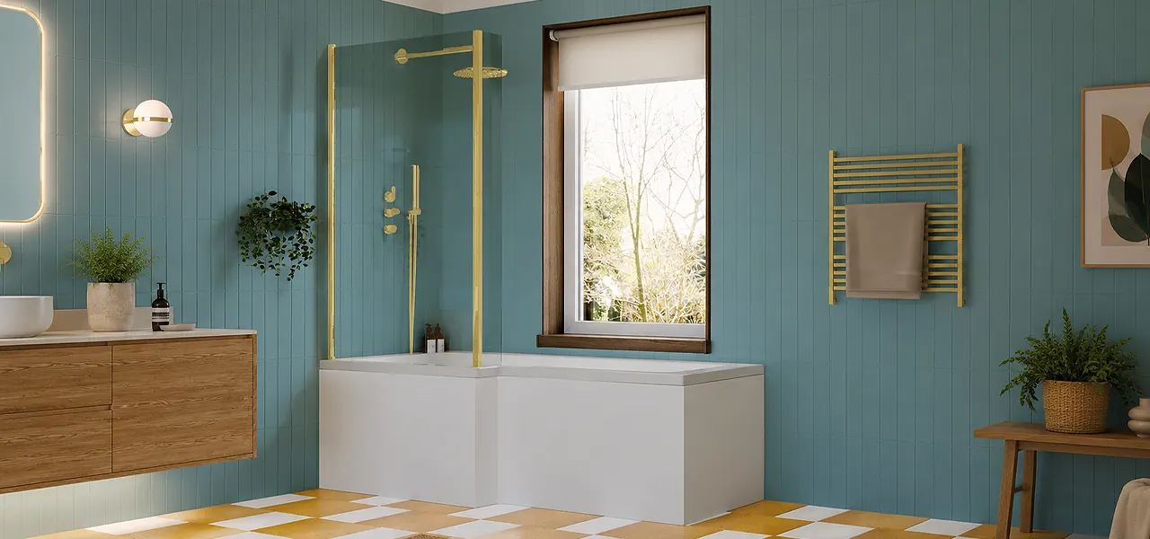 White L-shaped shower bath with a brushed brass framed shower screen and matching brass shower, in a teal-panelled bathroom beside a window.