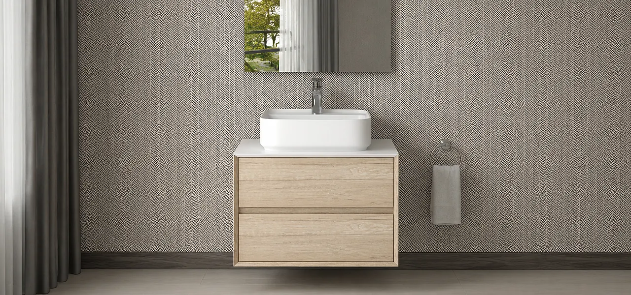 Natural oak wall-hung two-drawer vanity unit with a white countertop basin and chrome tap, against a herringbone-tiled wall.