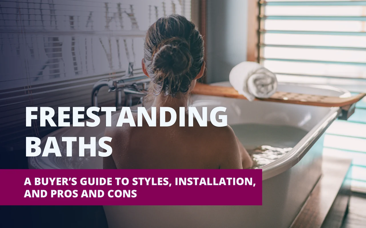 A woman soaking in a freestanding bathtub, viewed from behind, in a serene bathroom with natural light and horizontal blinds; bold text overlay reads “FREESTANDING BATHS – A Buyer’s Guide to Styles, Installation, and Pros and Cons.”