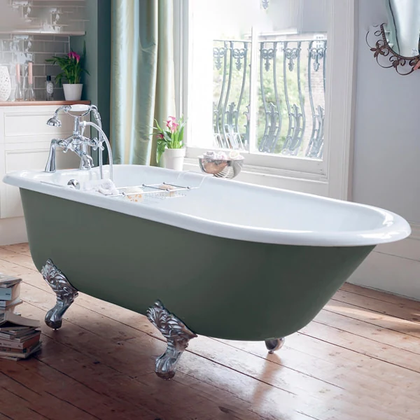 A classic clawfoot freestanding bathtub with an olive-green exterior and white interior, sitting in a bright bathroom with wood floors and large windows; the tub features ornate silver claw feet and vintage-style chrome fixtures.